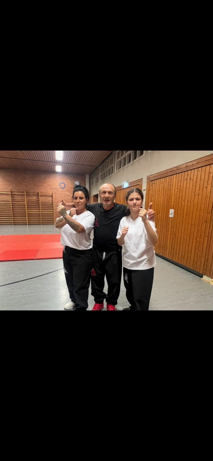 Trainer mit zwei Frauen in der Trainingshalle